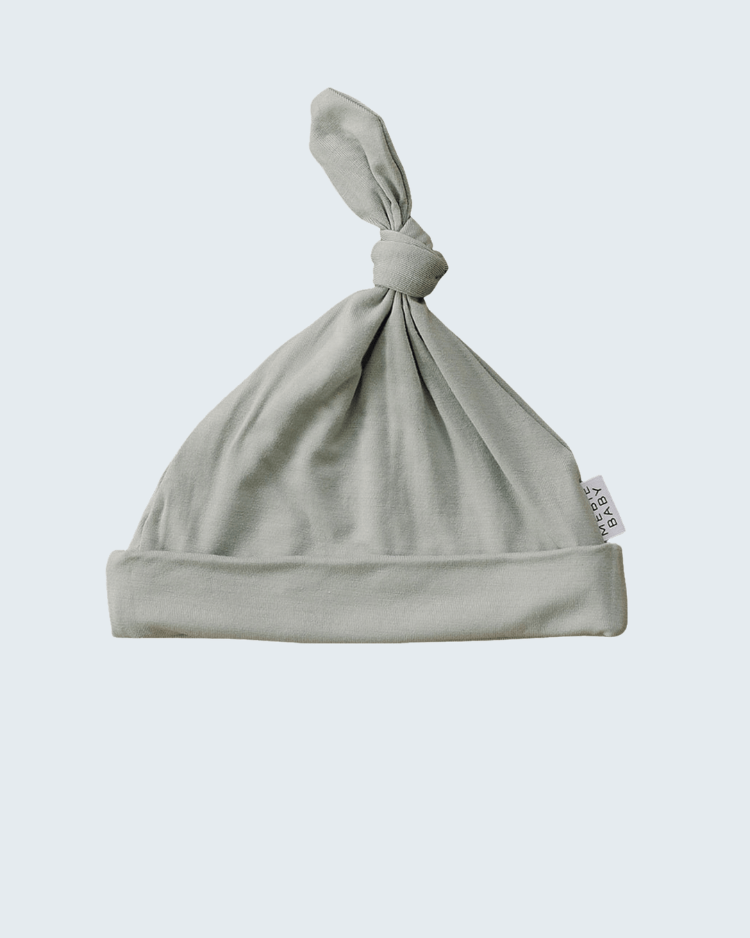 Sage baby hat with a knot on a light gray background