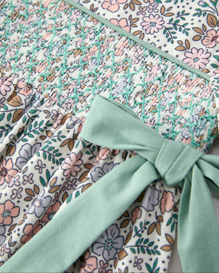 Close-up of floral smocked bodice with sage ribbon bow