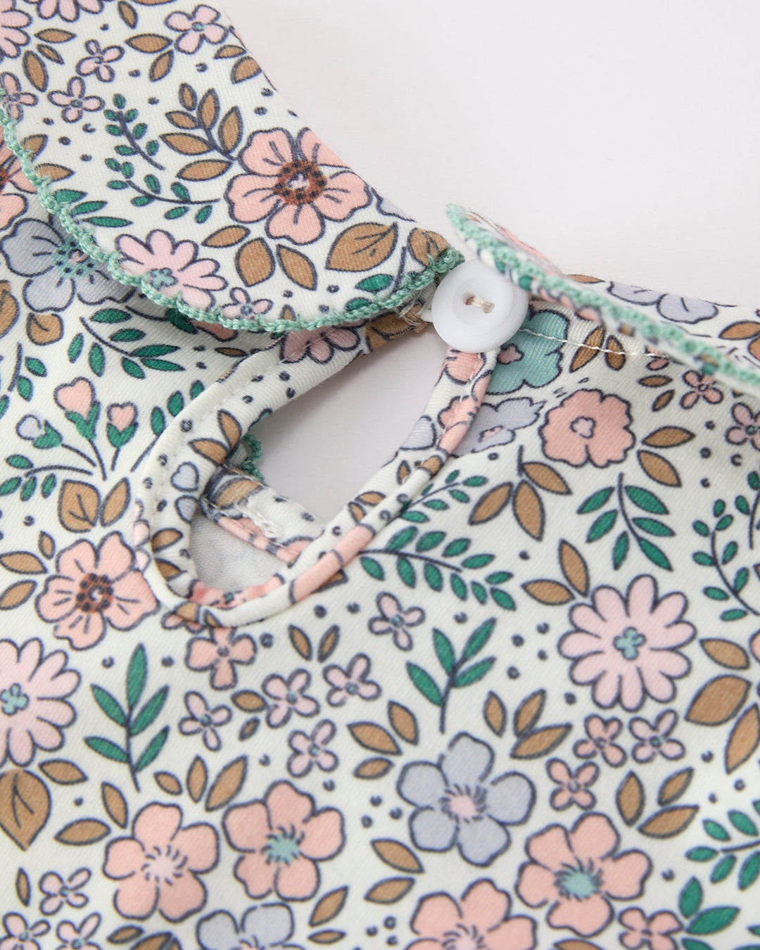 Girls floral dress neckline with button placket and sage trim