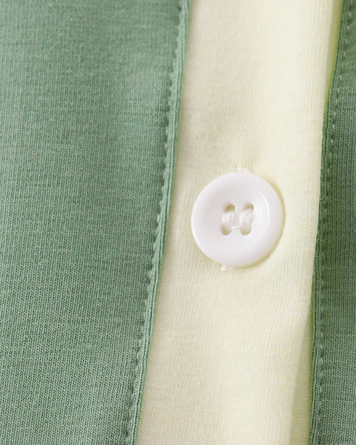 Sage green button-down shirt with cream placket and two-hole button.