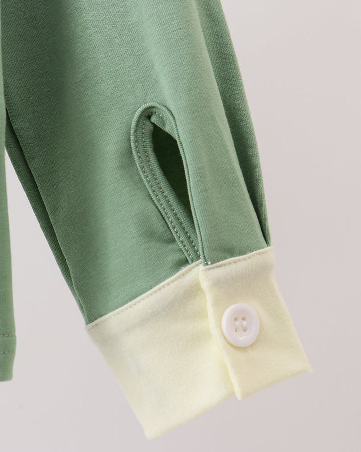 Sage green button-down shirt sleeve with cream cuff and button placket.