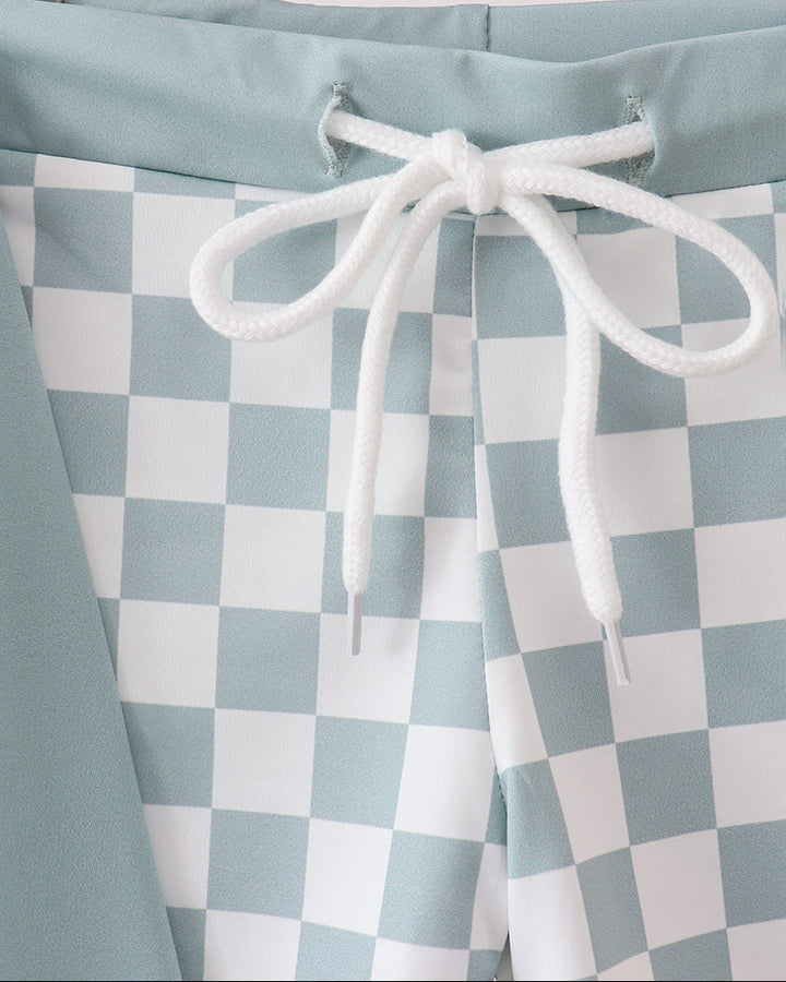 Checkered shorts with a white drawstring on a neutral background