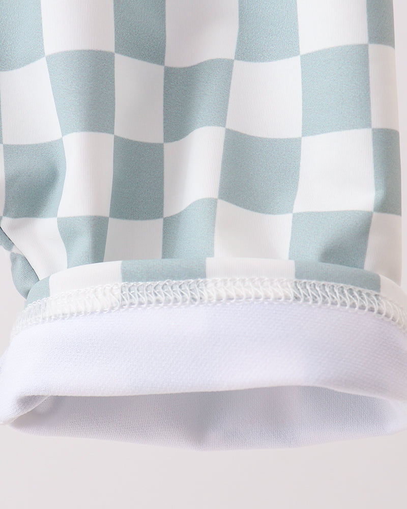 Close-up of a checkered fabric with light blue and white pattern on a plain background