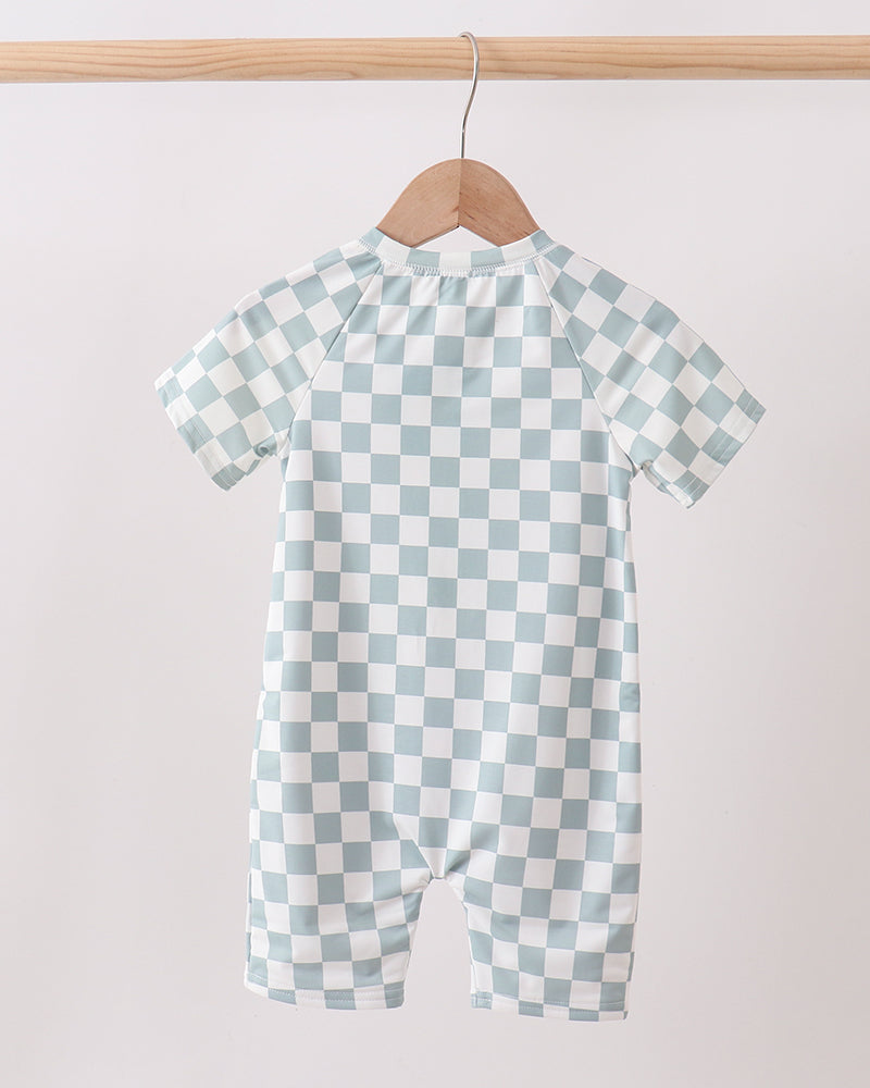 Checkered swimsuit on a hanger against a plain background