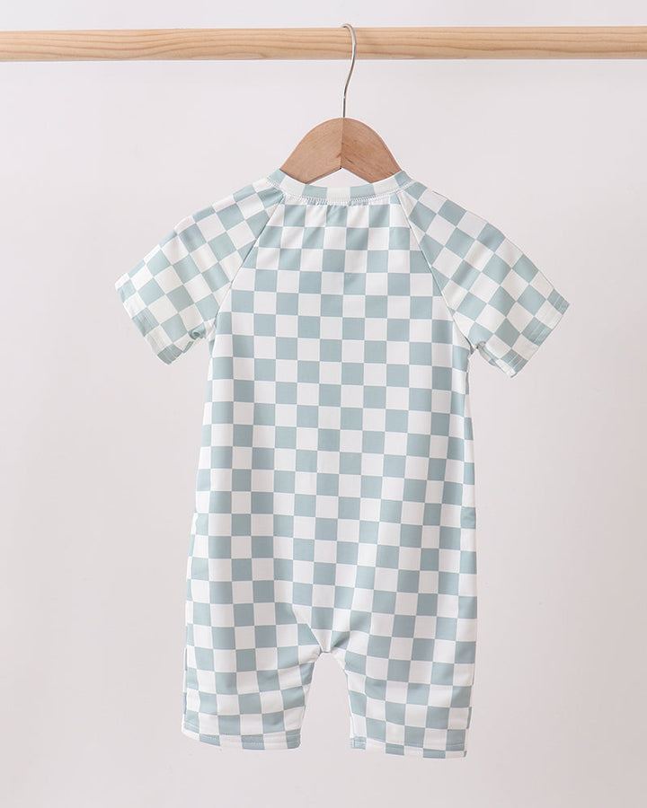Checkered swimsuit on a hanger against a plain background