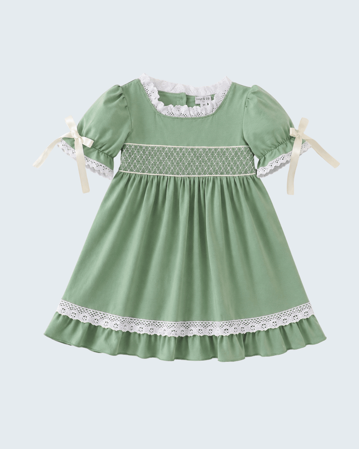 Sage green smocked dress with lace yoke, lace hem, and short puff sleeves with ribbon