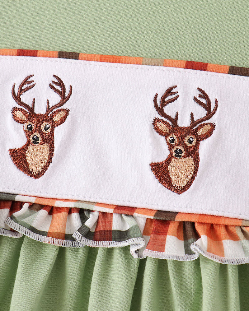 Close-up of embroidered deer faces on white yoke panel with ruffle trim