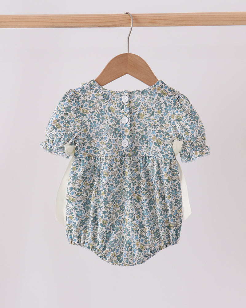 Blue floral bubble romper with button-back keyhole and gathered ruffle neckline