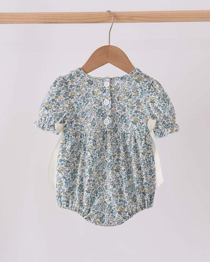 Blue floral bubble romper with button-back keyhole and gathered ruffle neckline