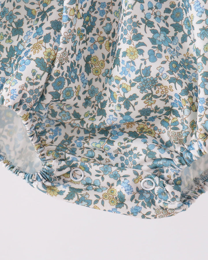 Blue floral bubble romper with ruffled leg openings and gathered fabric