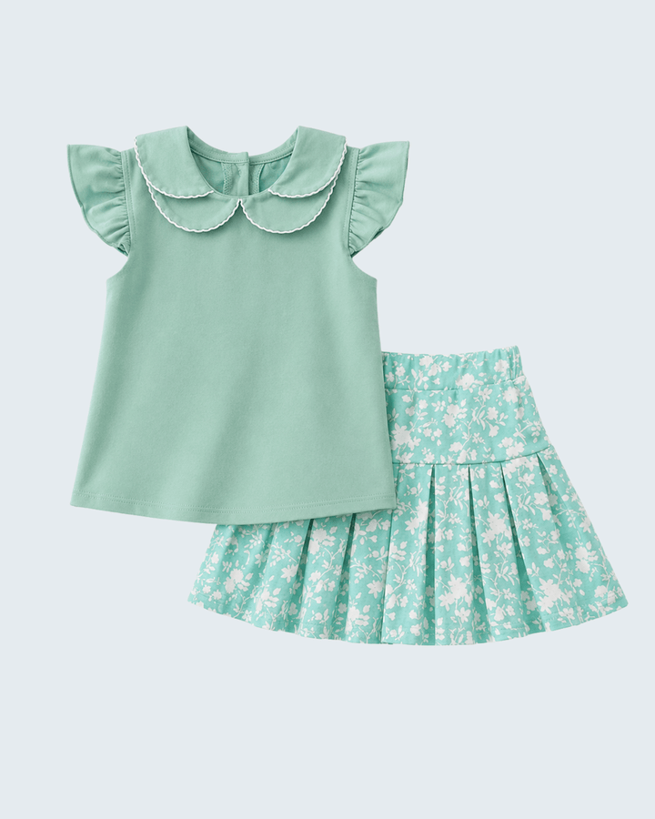 Green top and floral skirt set on a light blue background