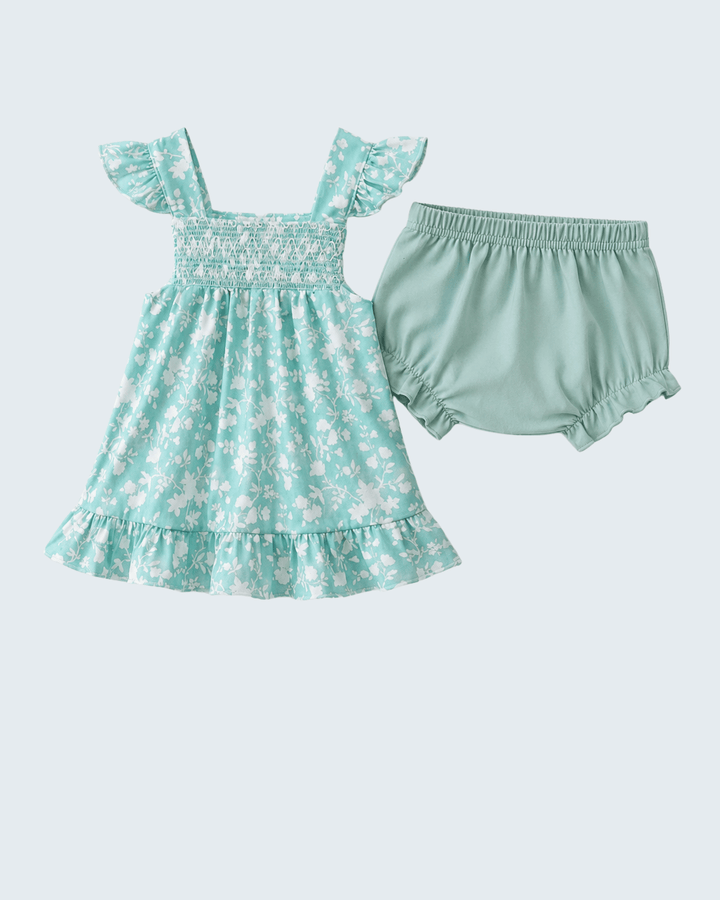 Mint green baby dress with floral pattern and matching bloomers on a light blue background