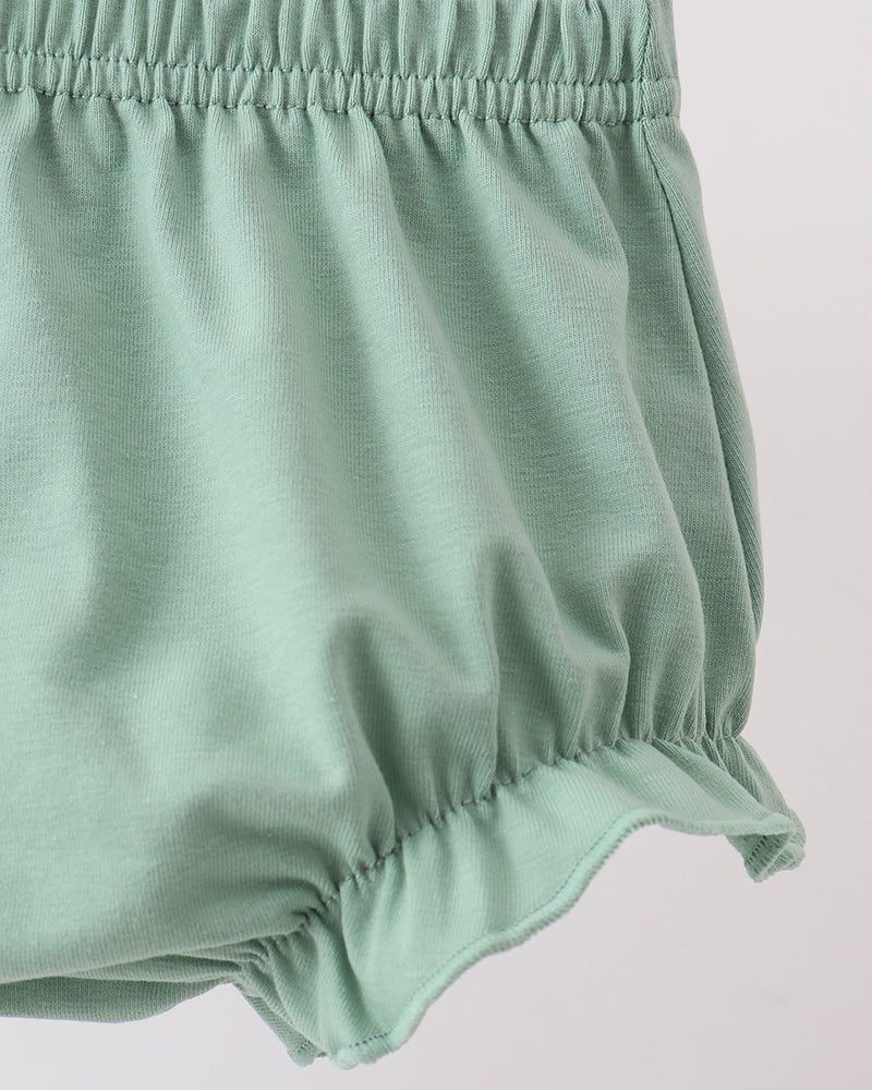 Green baby bloomers on a light gray background