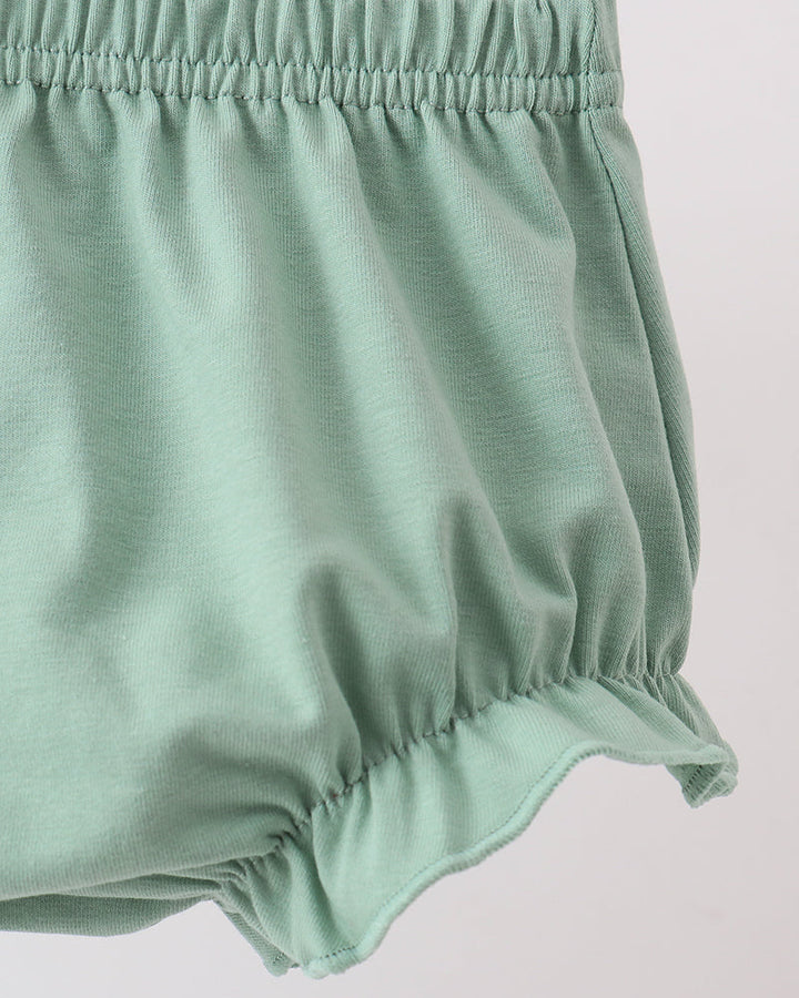 Green baby bloomers on a light gray background