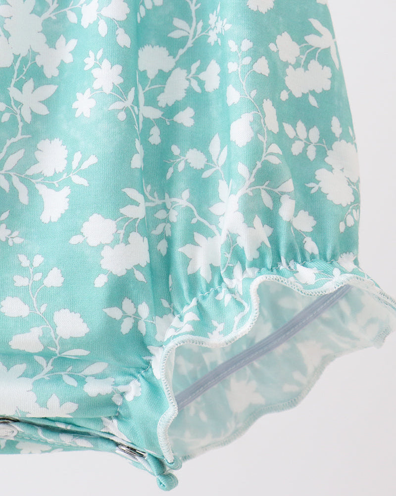 Teal fabric with white floral pattern on a white background