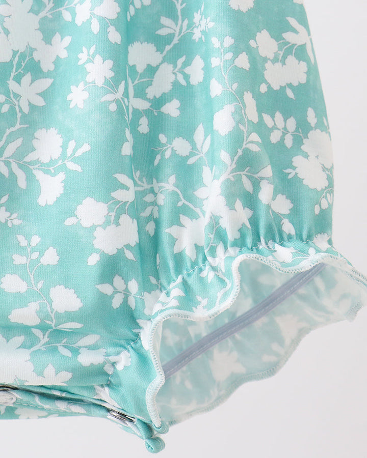 Teal fabric with white floral pattern on a white background