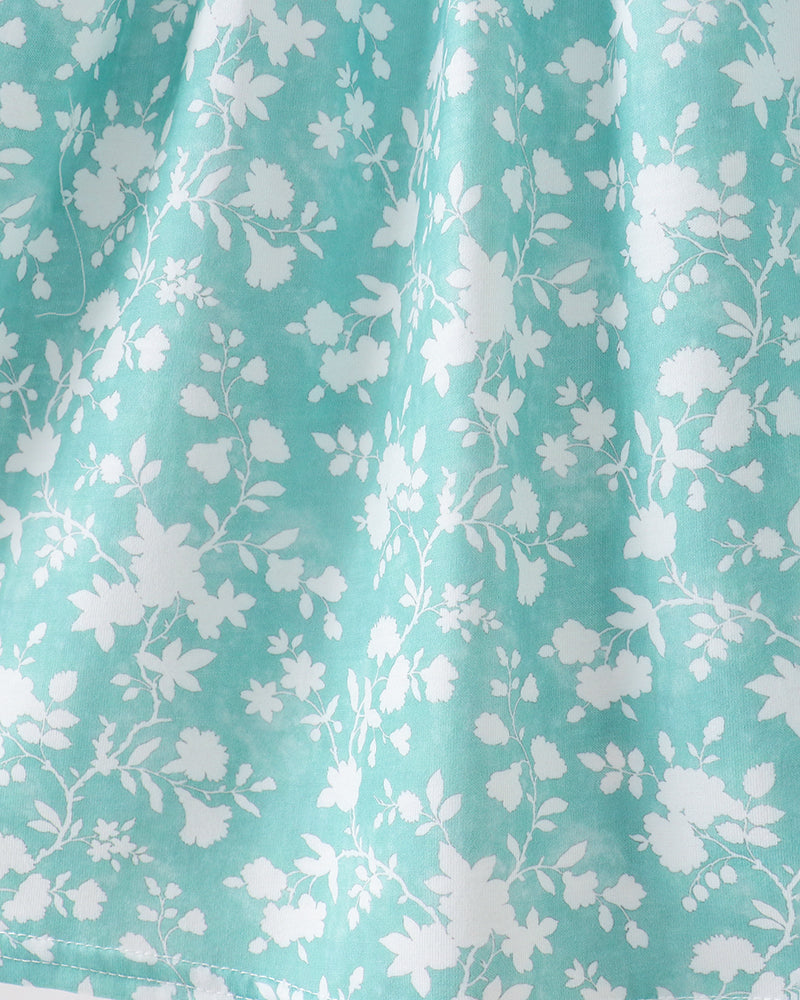 Close-up of teal fabric with white floral pattern