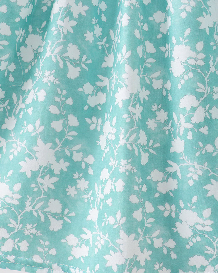 Close-up of teal fabric with white floral pattern