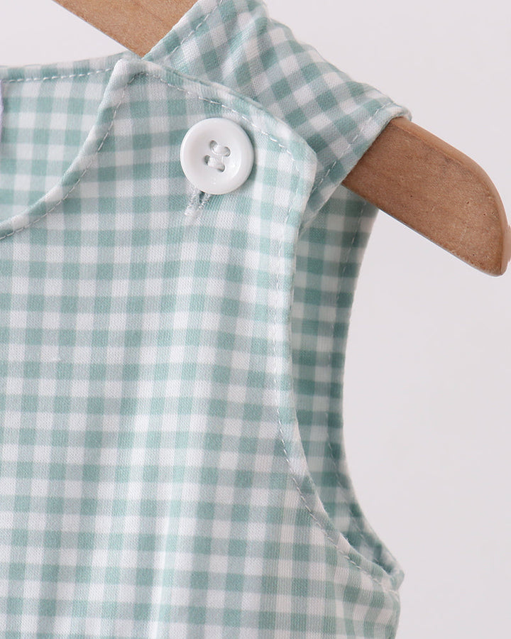 Green and white checkered baby romper on a wooden hanger against a white background