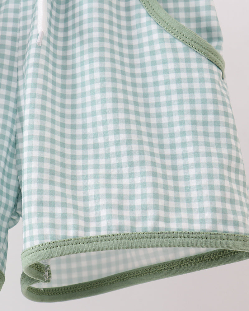 Green and white checkered fabric with a visible seam on a light gray background
