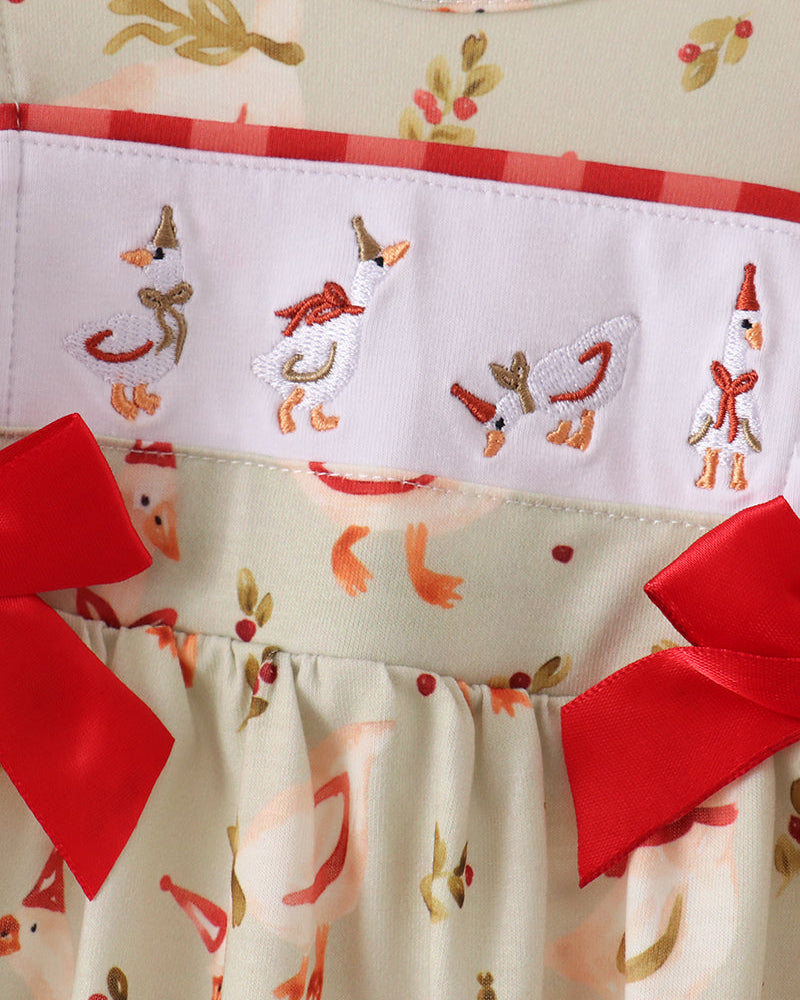Cream embroidered romper with red ruffle bows and colorful animal motifs, gathered bodice