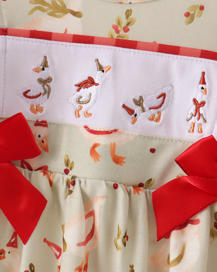 Cream embroidered romper with red ruffle bows and colorful animal motifs, gathered bodice