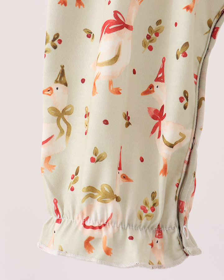 Cream long-sleeve romper with allover animal print and elastic cuffs, ruffled hem
