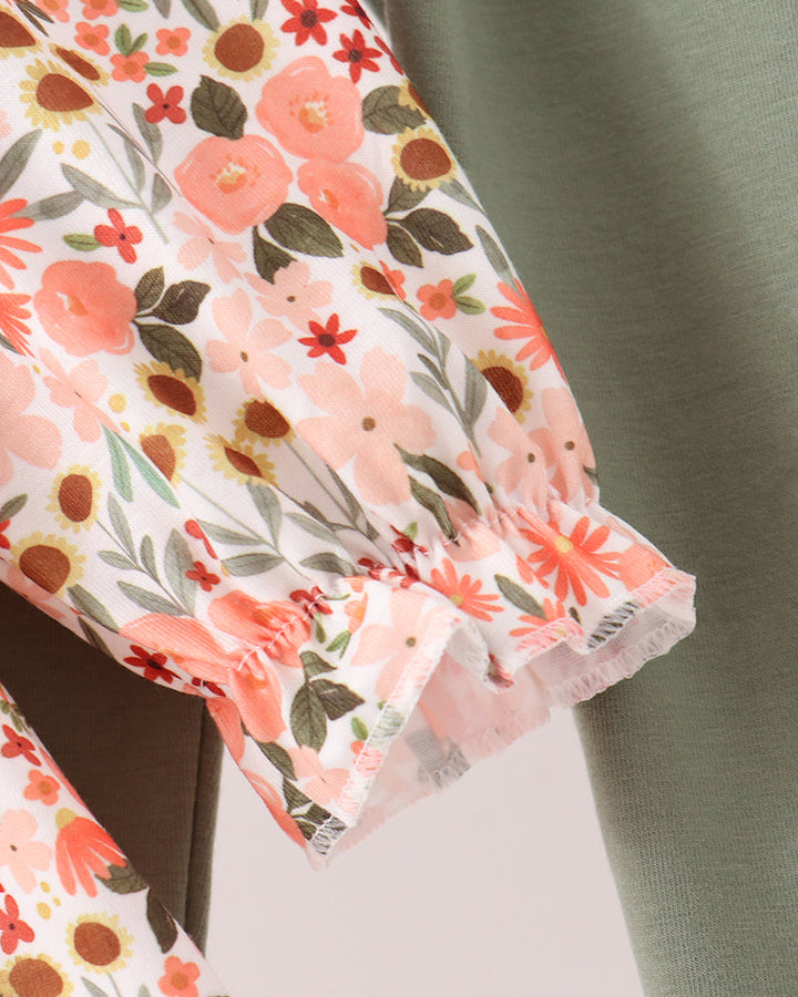 Floral ruffle sleeve with pastel pink and orange blossoms, paired with green pants
