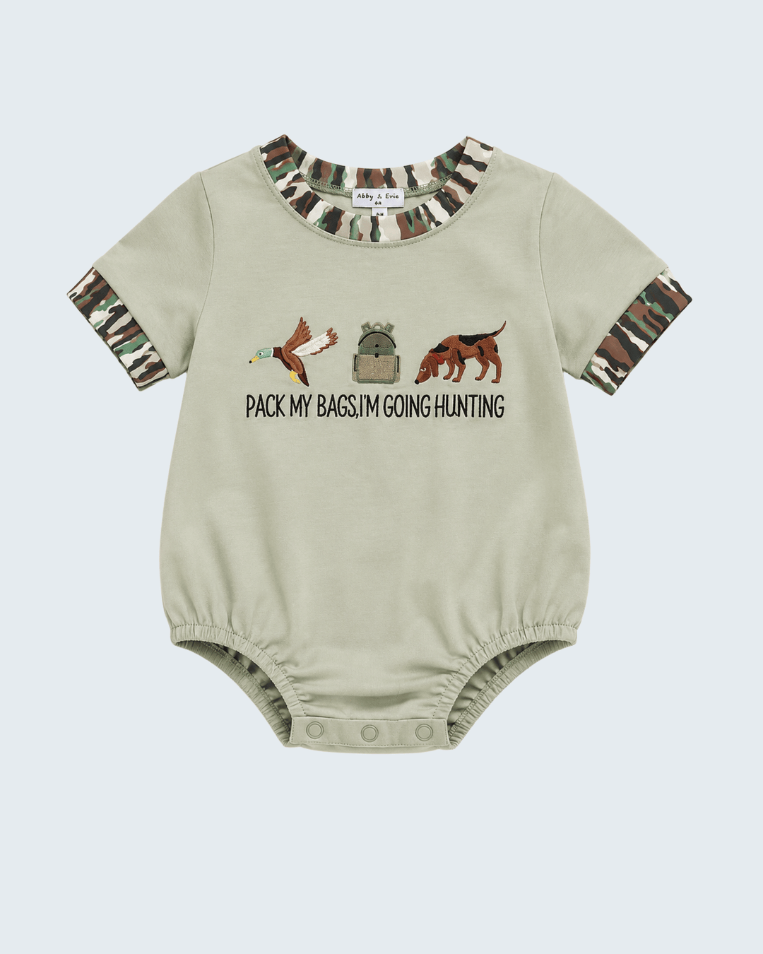 A baby short-sleeve bodysuit in light beige, featuring a camouflage print on the collar and cuffs, with a hunting-themed graphic and the text 'PACK MY BAGS I'M GOING HUNTING' on the chest.