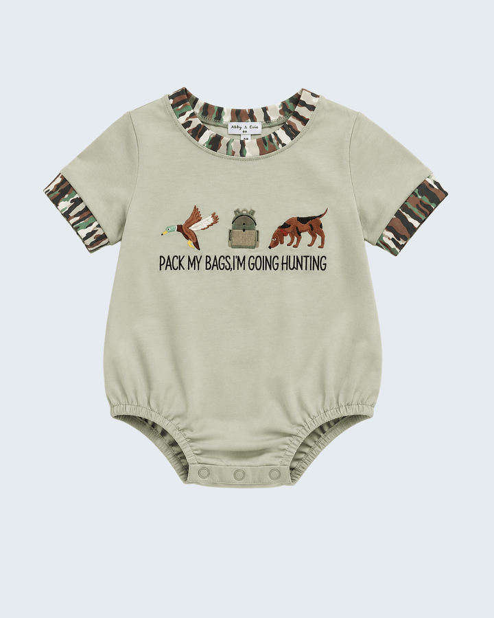 A baby short-sleeve bodysuit in light beige, featuring a camouflage print on the collar and cuffs, with a hunting-themed graphic and the text &