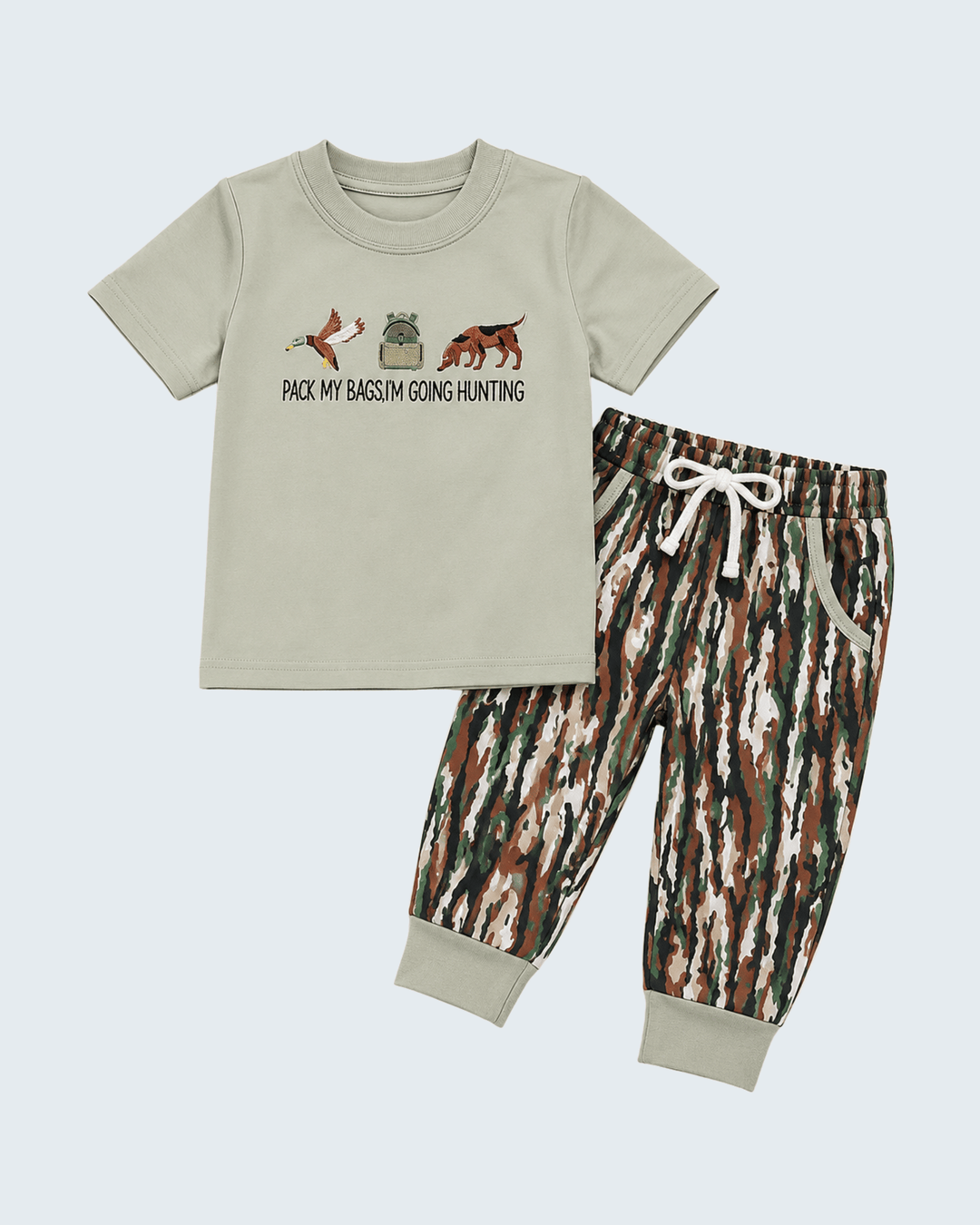 A two-piece kids' outfit set featuring a light sage green t-shirt with a hunting-themed graphic and text, paired with matching camouflage print jogger pants with a white drawstring.
