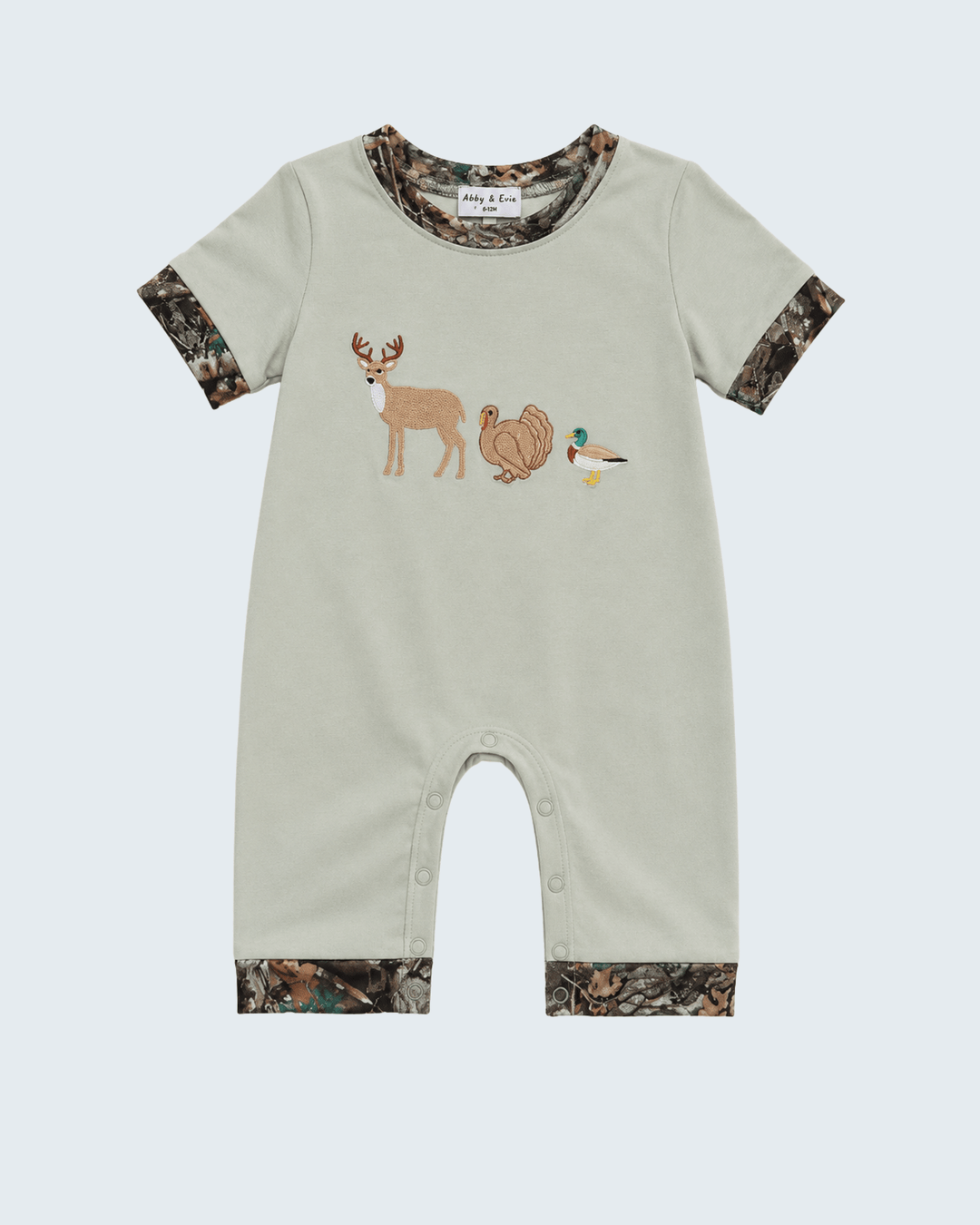 A baby short-sleeve romper in light sage green, featuring camouflage-patterned trim on the cuffs and hem, with embroidered deer, turkey, and duck motifs on the chest, shown against a light gray background.