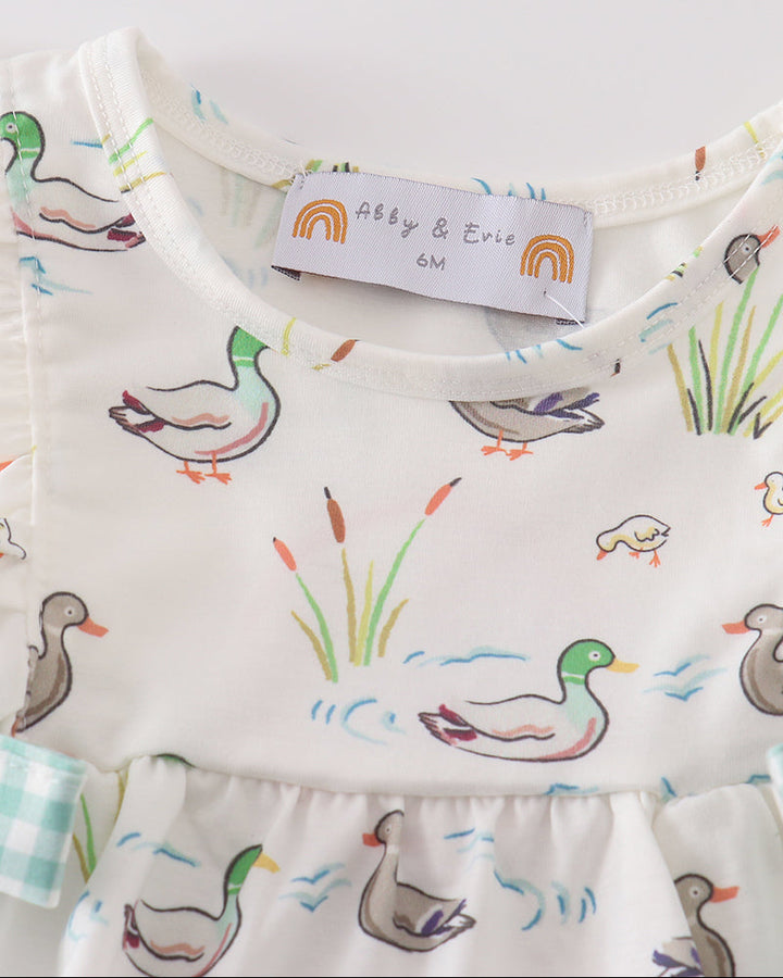White duck-print baby romper with ruffled neckline and multicolor graphic pattern