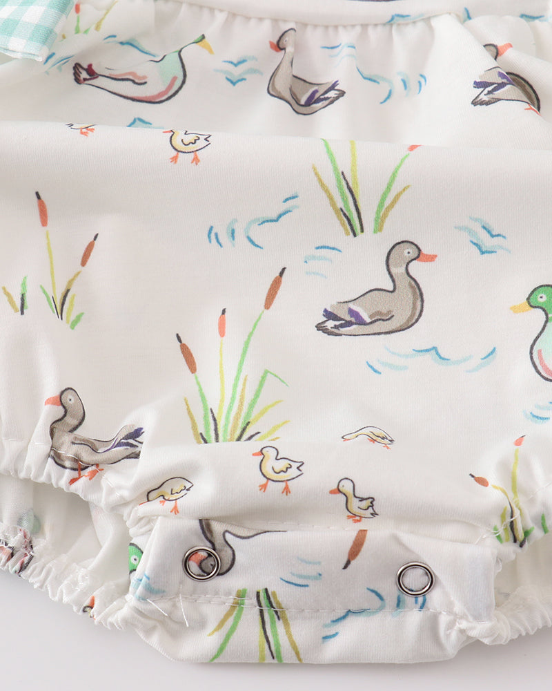 White duck-and-reed baby bubble romper with gathered waist and ruffle hem