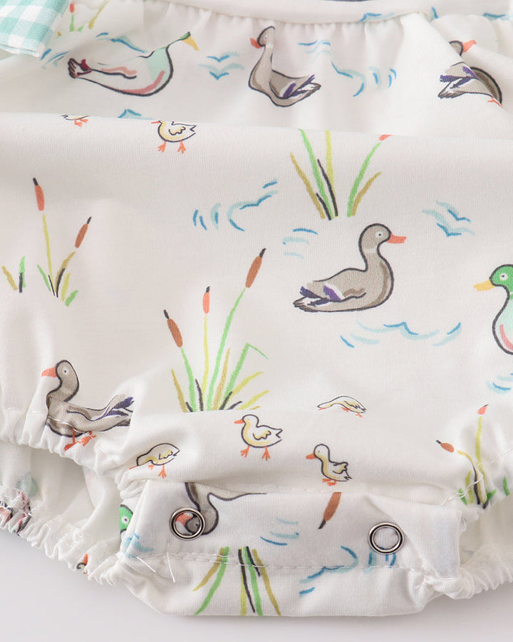 White duck-and-reed baby bubble romper with gathered waist and ruffle hem