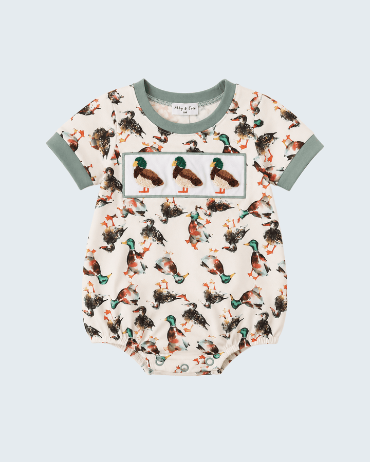 Baby of Lou short-sleeve bodysuit featuring a multicolor mallard duck print on a cream background, with sage green trim on the collar and sleeves.