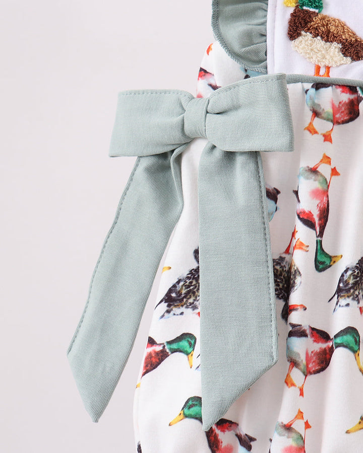 Infant romper waist with sage bow tie and gathered ruffle trim over bird print