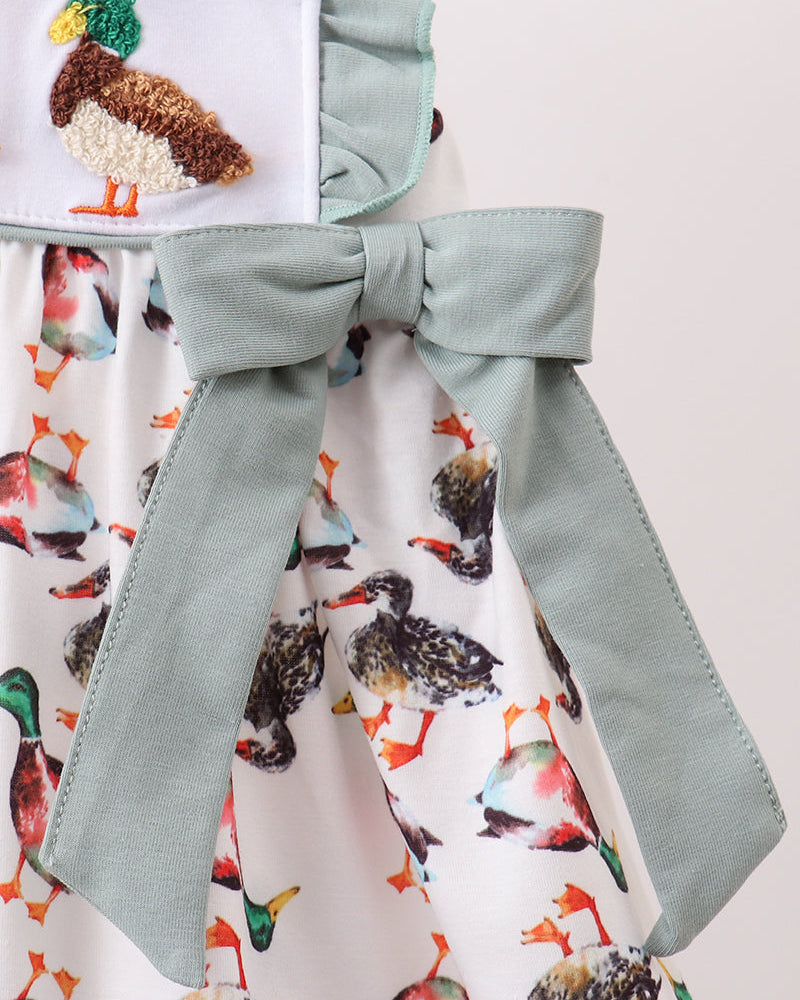 Bird-print dress with sage-green bow at waist and layered skirt ruffles
