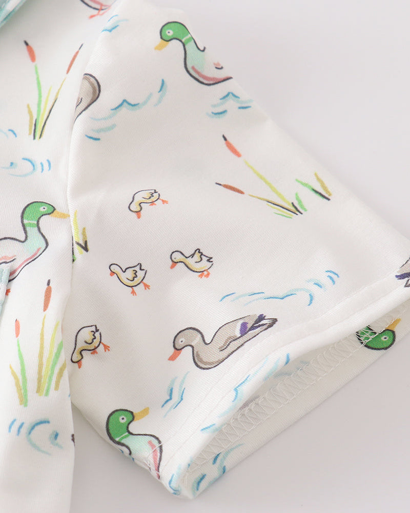 Duck print fabric close-up in white with green, blue, and orange details