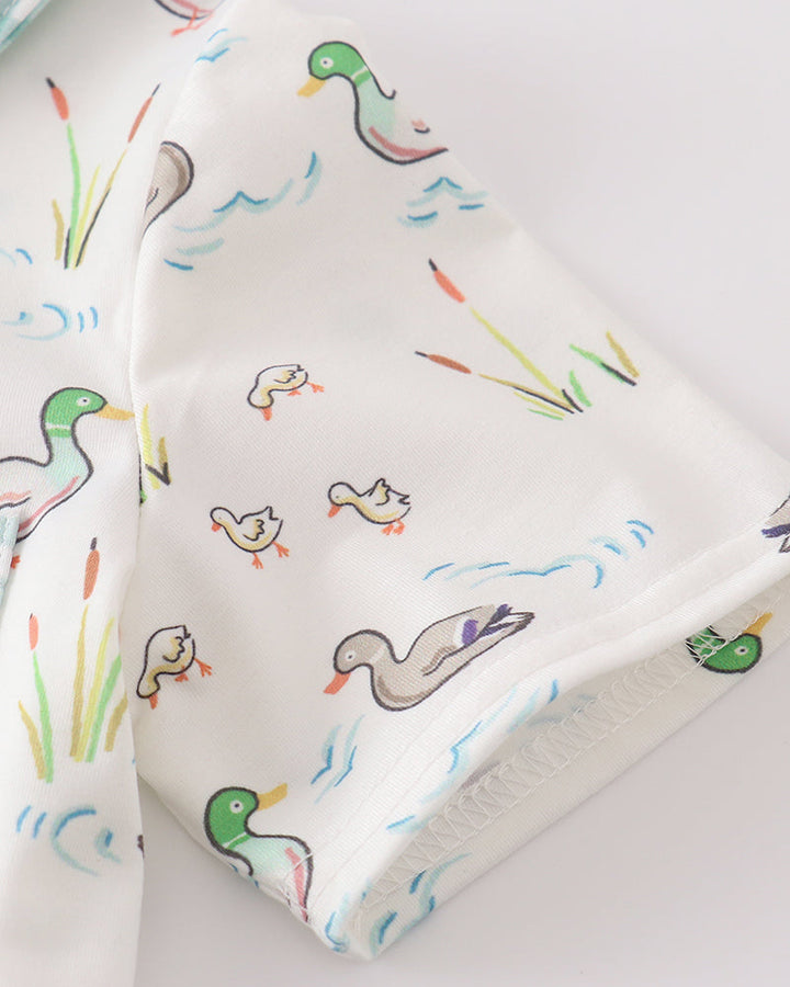 Duck print fabric close-up in white with green, blue, and orange details