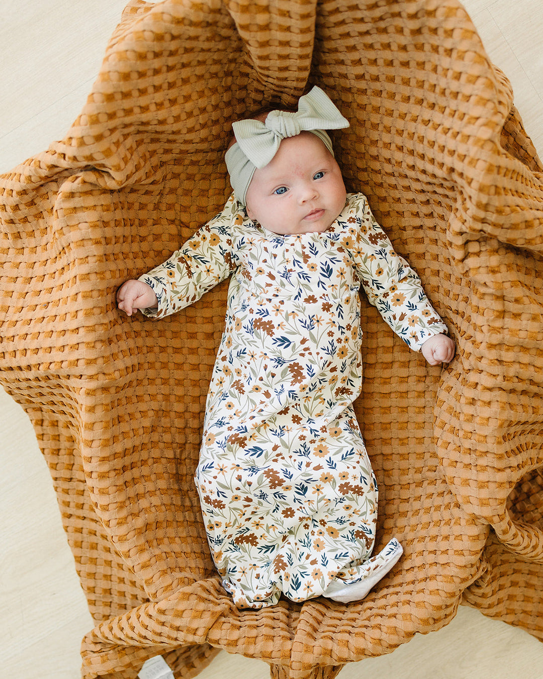 Sage ribbed head wrap with small knot bow on top, baby wearing
