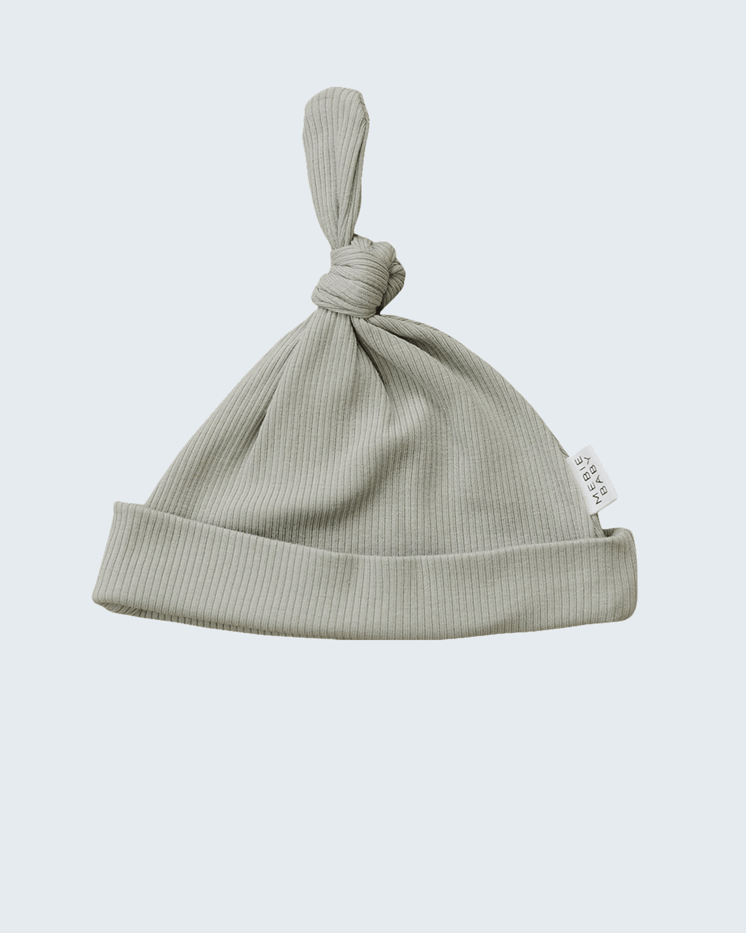Green baby hat with knot on a light gray background
