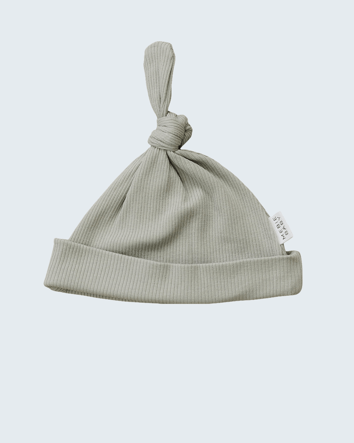 Green baby hat with knot on a light gray background