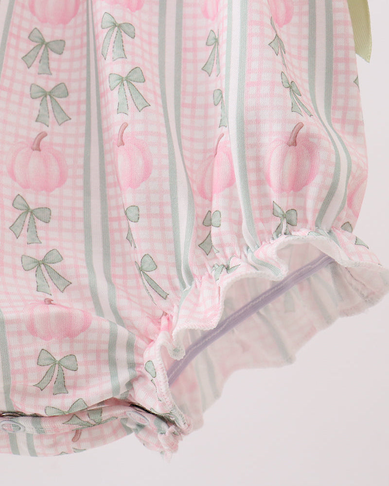 Close-up of pink plaid baby romper with green edge trim and sheer tulle-like hem