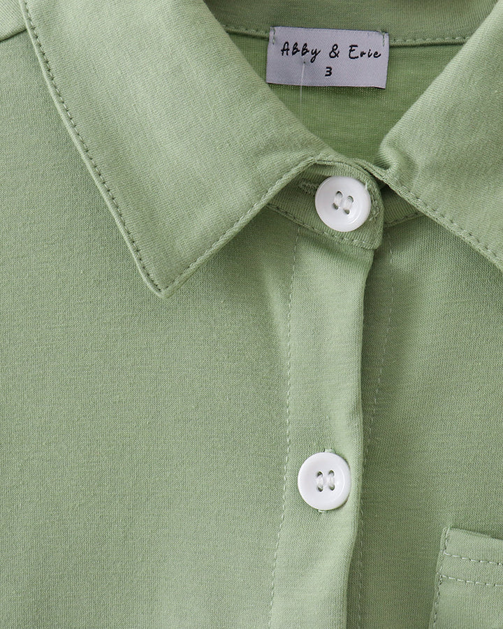 Sage green button-down shirt closeup: pointed collar, placket buttons, stitched seams