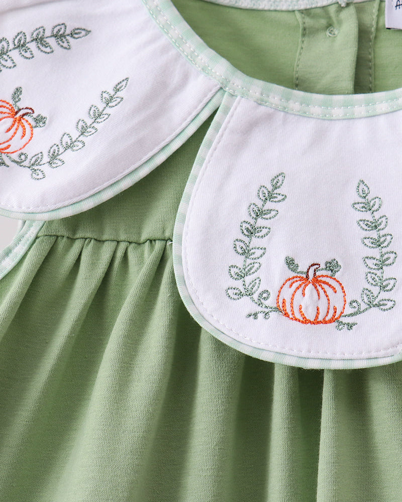 Sage green sleeveless ruffle top with white pumpkin embroidery bib detail
