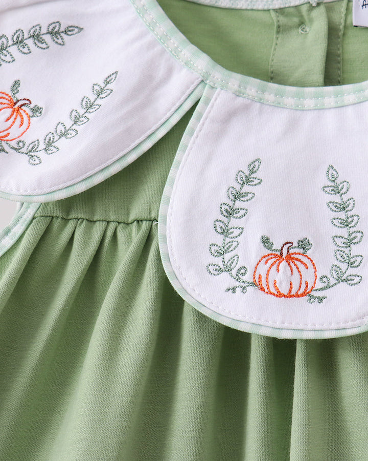 Sage green sleeveless ruffle top with white pumpkin embroidery bib detail