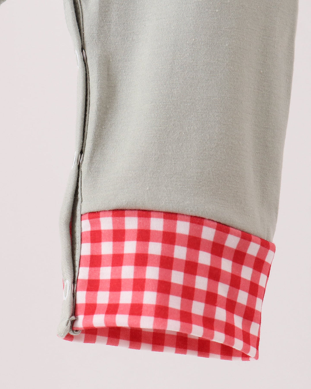 Sage green toddler romper with red-and-white gingham sleeve cuff and gathered hem