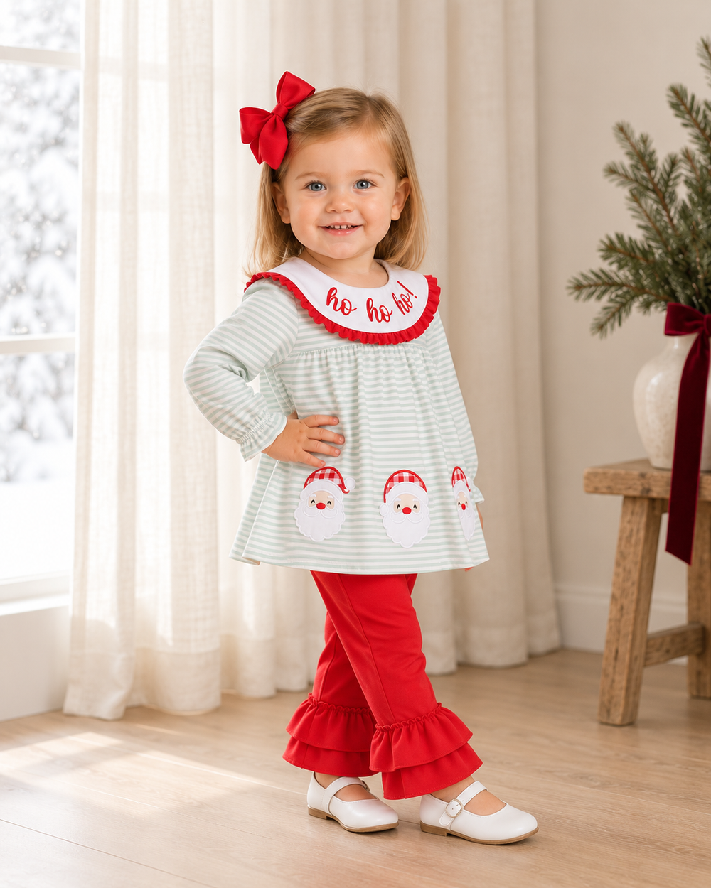 Toddler wearing mint striped Santa top with red ruffle collar and red ruffle pants