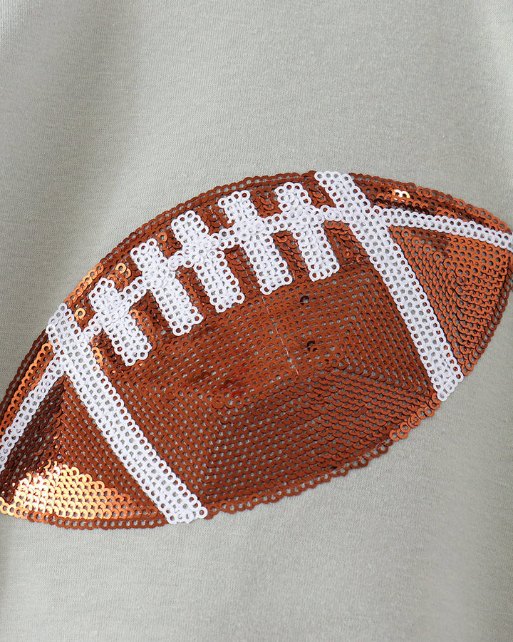Close-up of orange-and-white football sequins on sage green romper